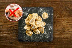 vassoio con cappelletti e cerchi con uova sbarrate da una x rossa