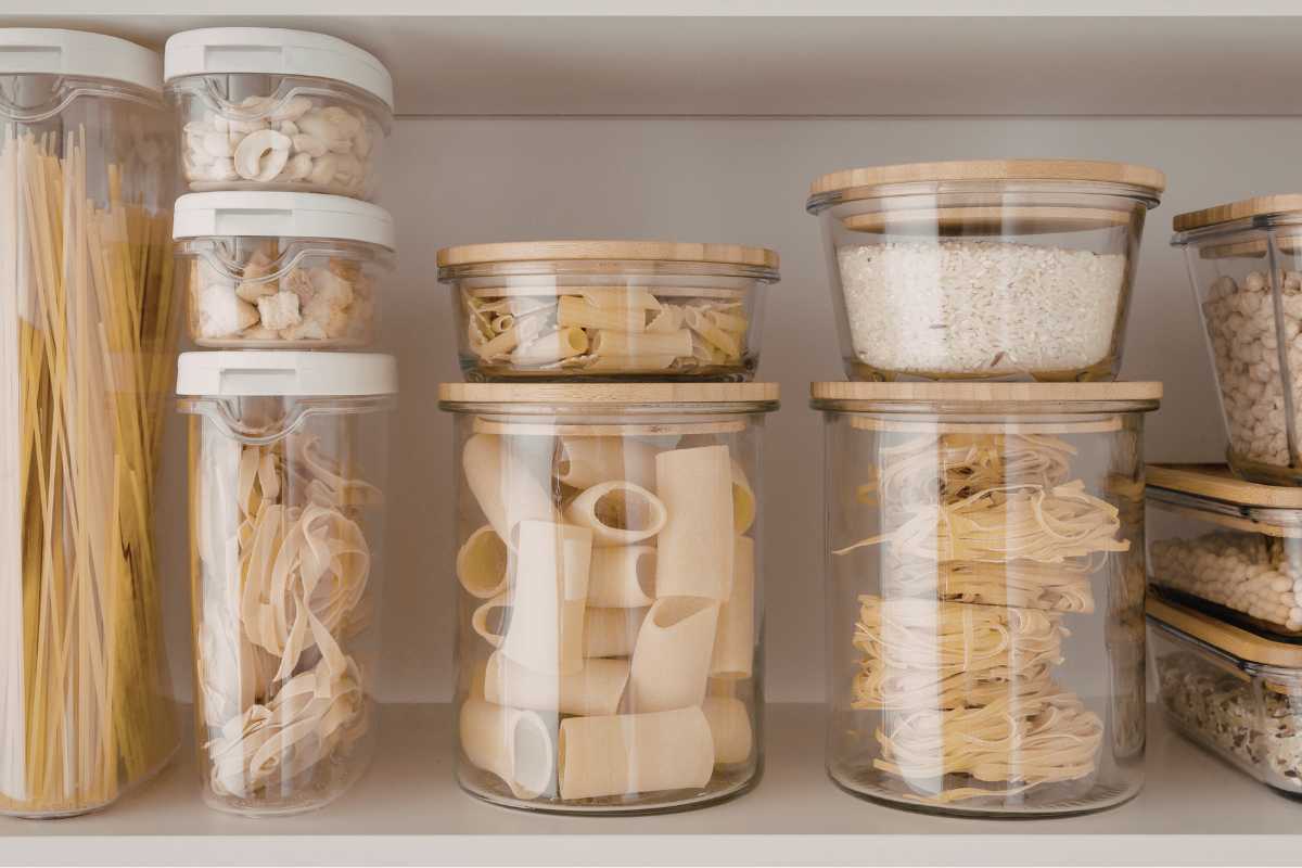 contentori impilati in vetro con dentro pasta nella dispensa 