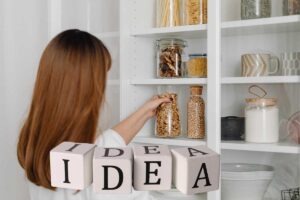 donna che tocca contenitori in vetro nella dispensa e scritta idea