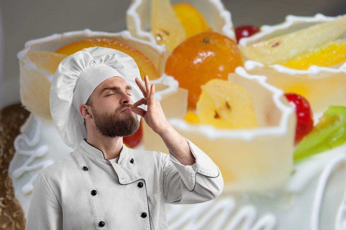 come sfondo una cassata siciliana e in primo piano uno chef