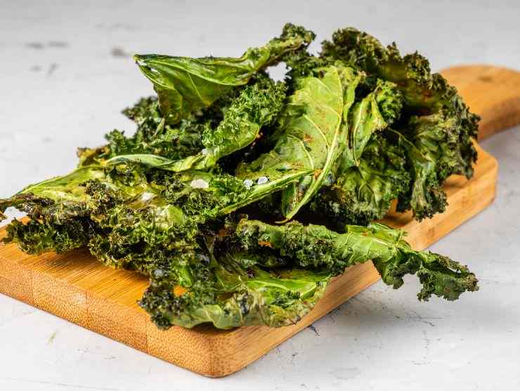 chips si cavolo nero su un tagliere in legno