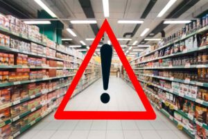 corsia supermercato e simbolo attenzione in rosso