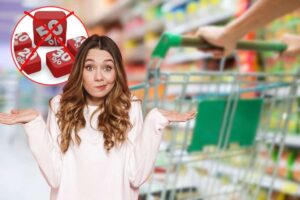 donna che porta carrello al supermercato, sconti in icona rossa e donna dispiaciuta in primo piano