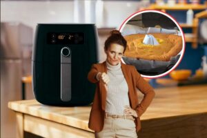 una cucina con una friggitrice ad aria, una torta cruda e una donna con il pollice verso il basso
