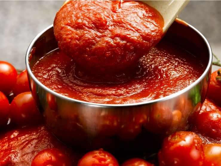 pentola piena di sugo di pomodoro